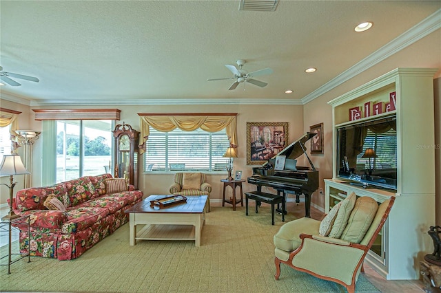 living room with ornamental molding, plenty of natural light, visible vents, and ceiling fan