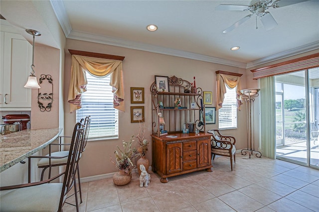 dining area featuring light tile patterned floors, plenty of natural light, baseboards, and crown molding