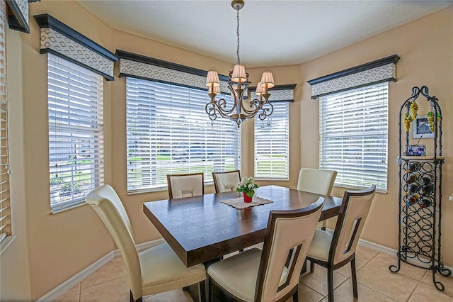 dining area featuring baseboards, a notable chandelier, and light tile patterned flooring