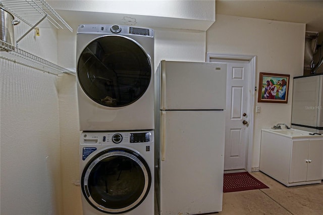 laundry room featuring stacked washer / drying machine, laundry area, and a sink