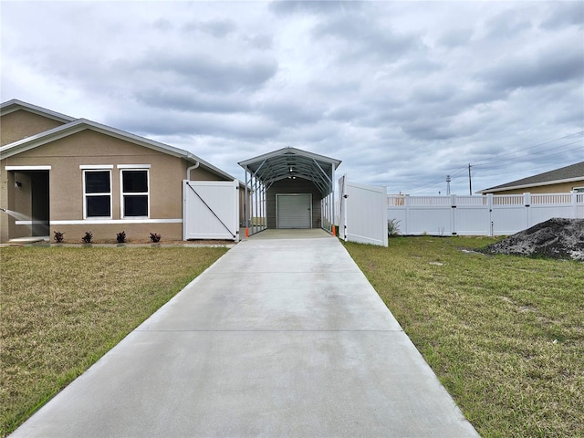 view of front of property featuring a gate, a front lawn, concrete driveway, and stucco siding