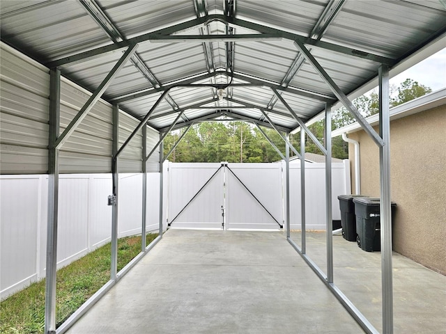 view of parking / parking lot featuring fence and a gate