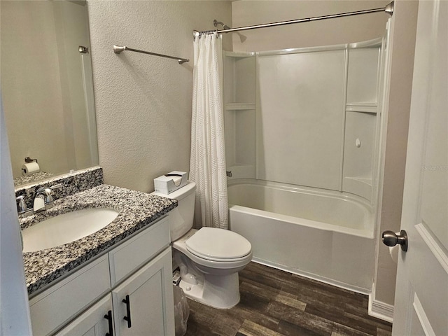 bathroom with shower / bathtub combination with curtain, a textured wall, vanity, and wood finished floors