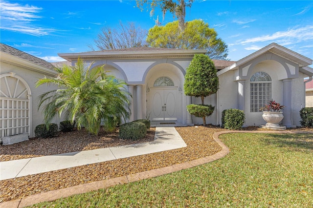 view of front of property featuring a front lawn and stucco siding