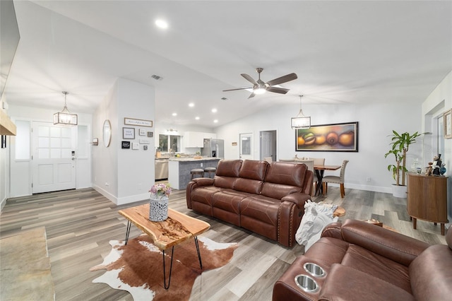 living area with visible vents, baseboards, light wood-style flooring, vaulted ceiling, and recessed lighting