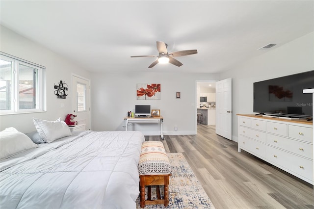 bedroom with light wood finished floors, baseboards, visible vents, and ceiling fan