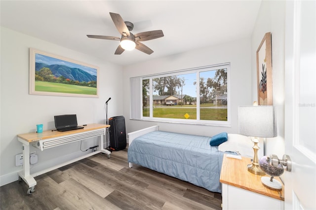 bedroom featuring a ceiling fan, baseboards, and wood finished floors