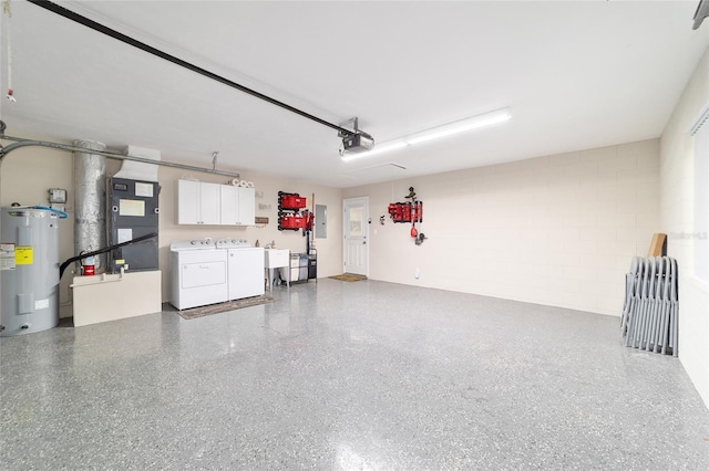 garage with concrete block wall, electric panel, a garage door opener, electric water heater, and washing machine and dryer