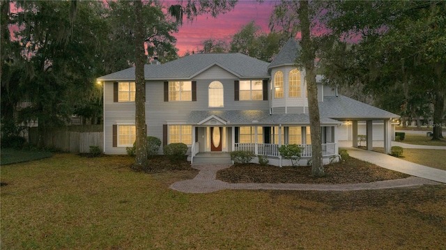 view of front of property featuring concrete driveway, an attached garage, fence, a porch, and a front yard