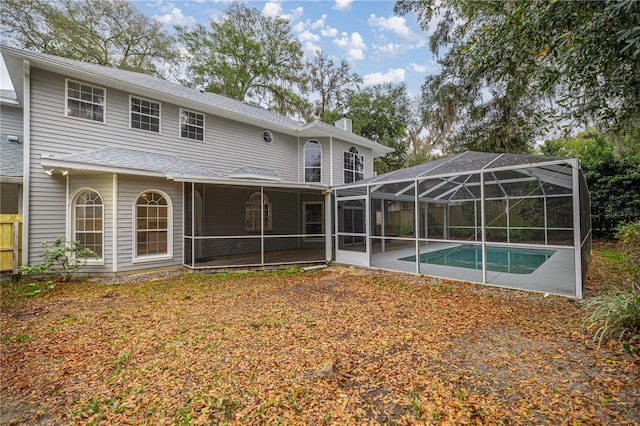 rear view of house with a lanai, a patio area, a chimney, and an outdoor pool