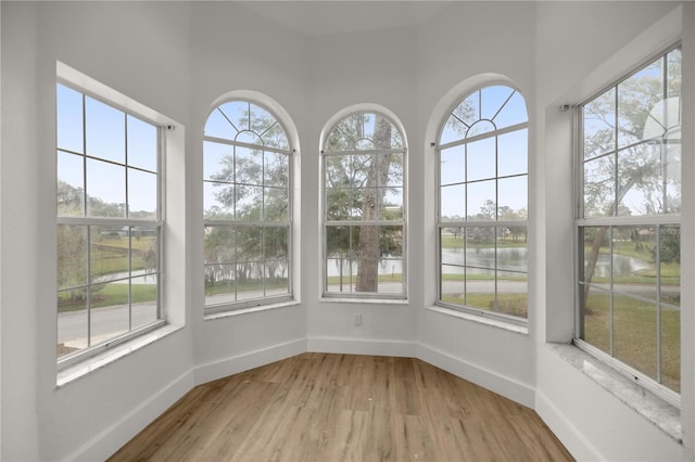 unfurnished sunroom with a water view