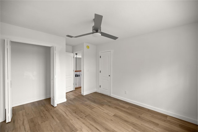 unfurnished bedroom featuring a ceiling fan, a closet, light wood-style flooring, and baseboards