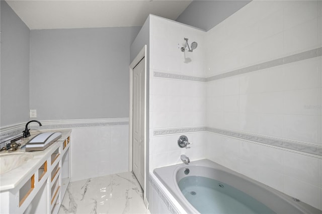 full bathroom with marble finish floor, tile walls, a closet, vanity, and a whirlpool tub