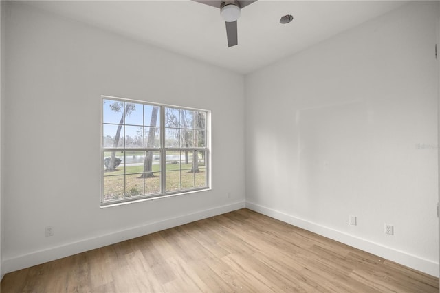 empty room featuring baseboards, ceiling fan, and light wood-style floors