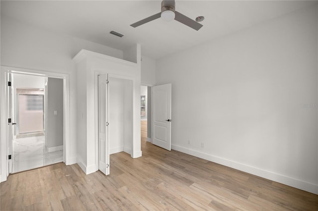 unfurnished bedroom featuring a ceiling fan, light wood-type flooring, visible vents, and baseboards