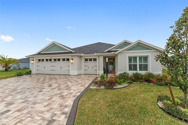 view of front of home with a garage, a shingled roof, decorative driveway, stucco siding, and a front yard