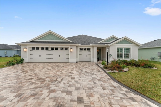 view of front of property with a garage, stucco siding, decorative driveway, and a front yard