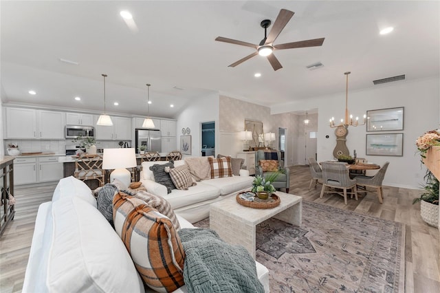 living room with lofted ceiling, visible vents, light wood finished floors, and recessed lighting