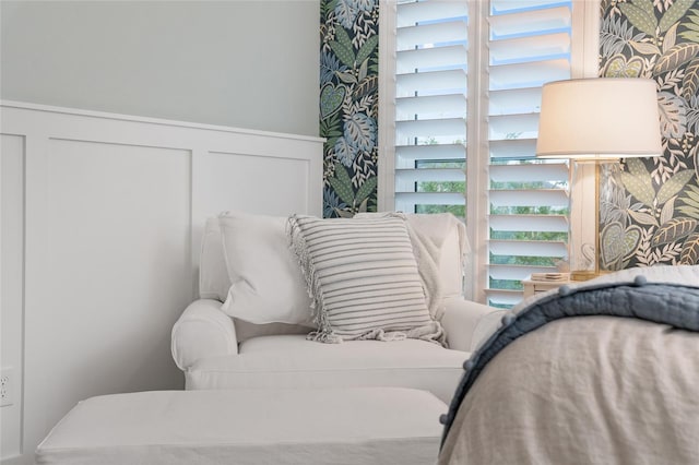 bedroom with a wainscoted wall, a decorative wall, and wallpapered walls