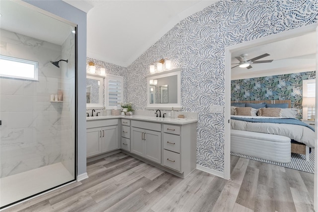 ensuite bathroom with wood finished floors, a tile shower, ensuite bath, and wallpapered walls