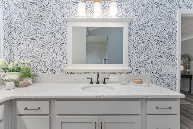 bathroom featuring vanity and wallpapered walls