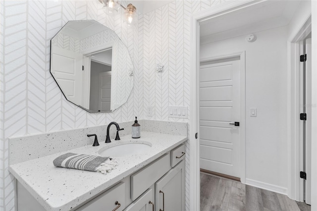 bathroom with wood finished floors, vanity, and baseboards