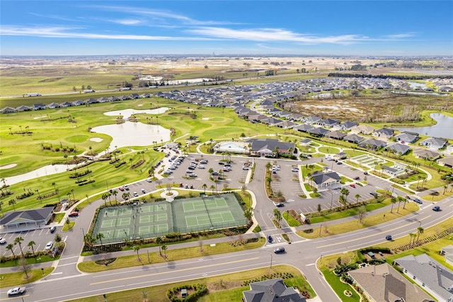 drone / aerial view with view of golf course, a water view, and a residential view