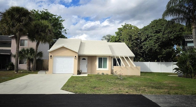 view of front of property with a garage, concrete driveway, a tile roof, fence, and a front lawn