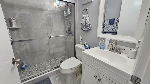 full bathroom featuring a shower stall, toilet, and vanity