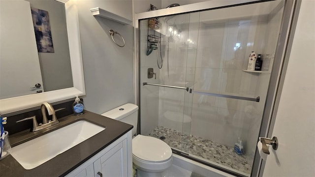 full bath with a stall shower, vanity, and toilet