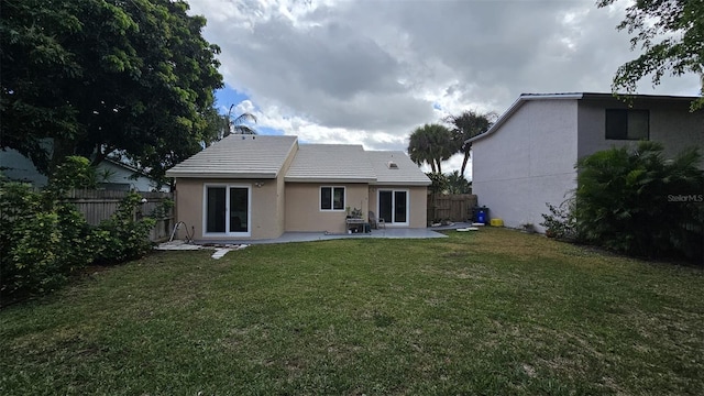 back of house featuring a patio area, a fenced backyard, stucco siding, and a yard