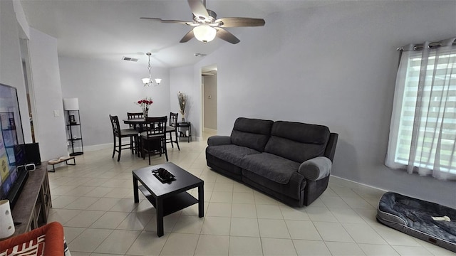 living area featuring light tile patterned floors, baseboards, visible vents, vaulted ceiling, and ceiling fan with notable chandelier