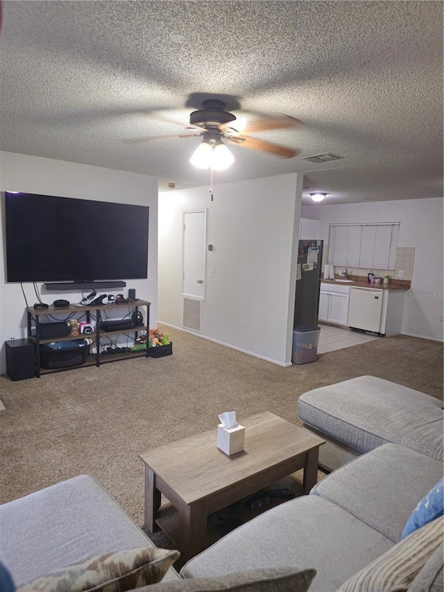 carpeted living area with ceiling fan, visible vents, and a textured ceiling