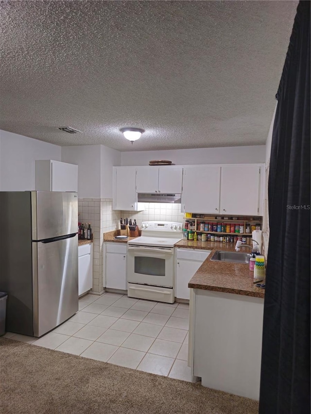 kitchen with white cabinets, freestanding refrigerator, white electric range, under cabinet range hood, and a sink