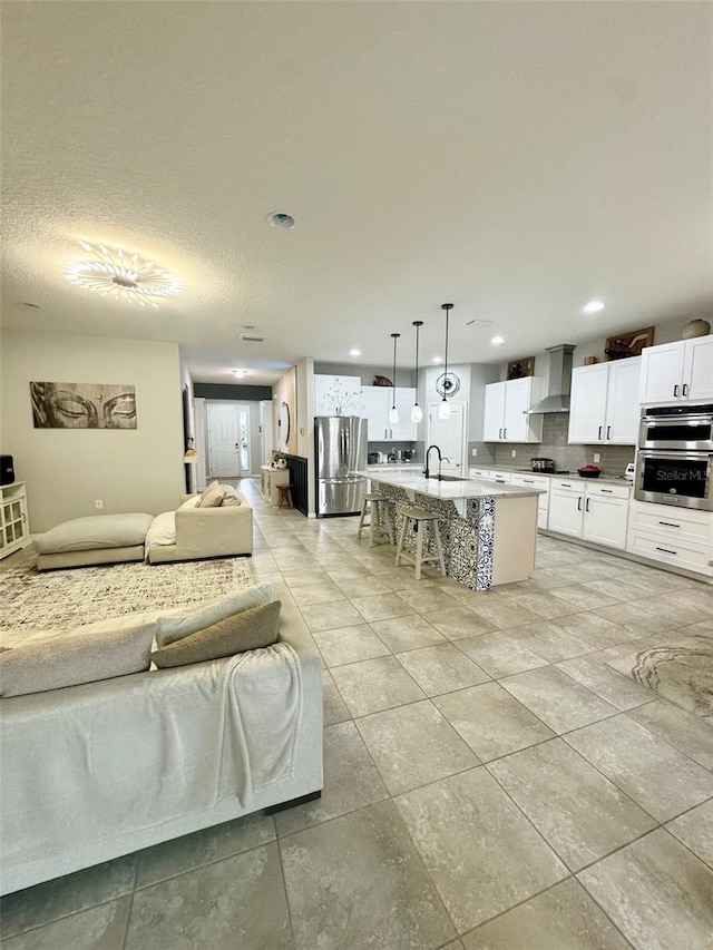 living area with a textured ceiling, light tile patterned floors, and recessed lighting