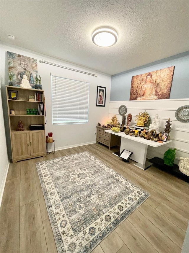 interior space with a textured ceiling and wood finished floors