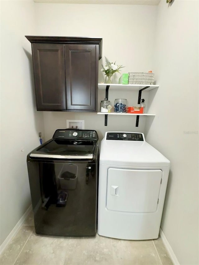 laundry room with cabinet space, washer and clothes dryer, and baseboards