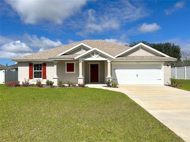 view of front of property featuring concrete driveway, a front lawn, fence, and stucco siding