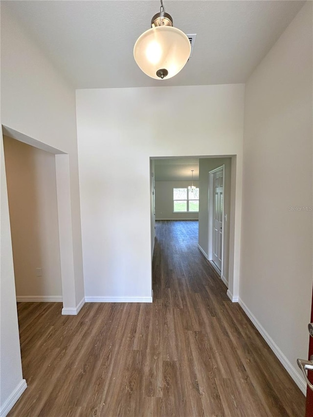 hallway with baseboards and dark wood finished floors