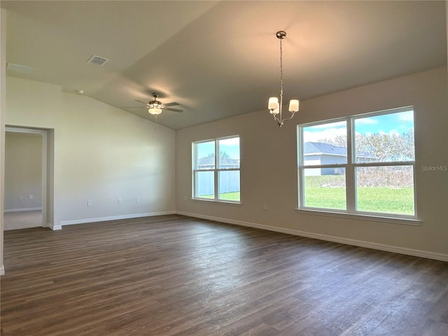 unfurnished room featuring baseboards, visible vents, lofted ceiling, dark wood-style flooring, and ceiling fan with notable chandelier