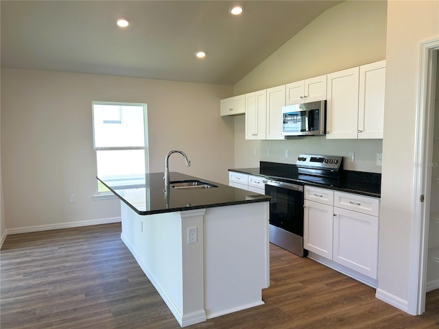 kitchen with dark countertops, stainless steel appliances, a sink, and lofted ceiling