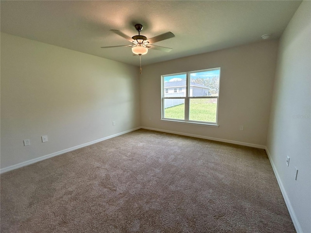 unfurnished room with carpet flooring, a ceiling fan, and baseboards