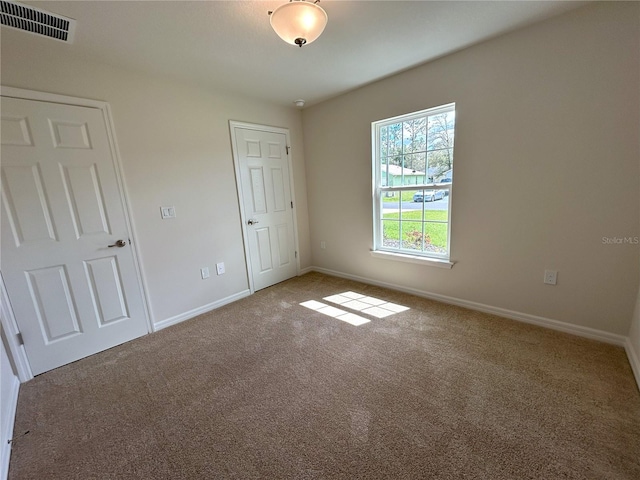 unfurnished bedroom with carpet floors, visible vents, and baseboards