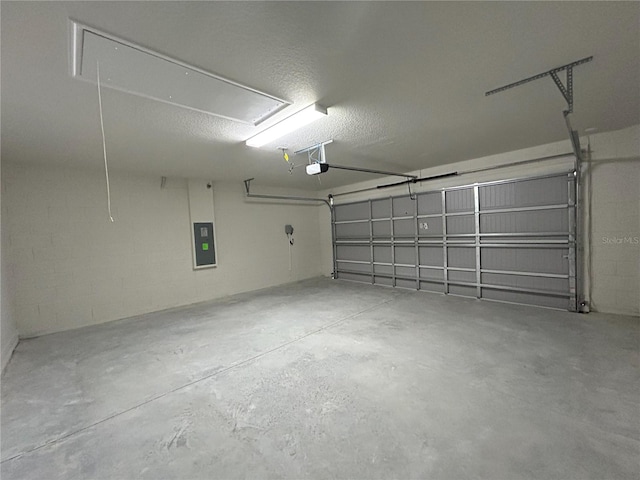 garage featuring concrete block wall, electric panel, and a garage door opener