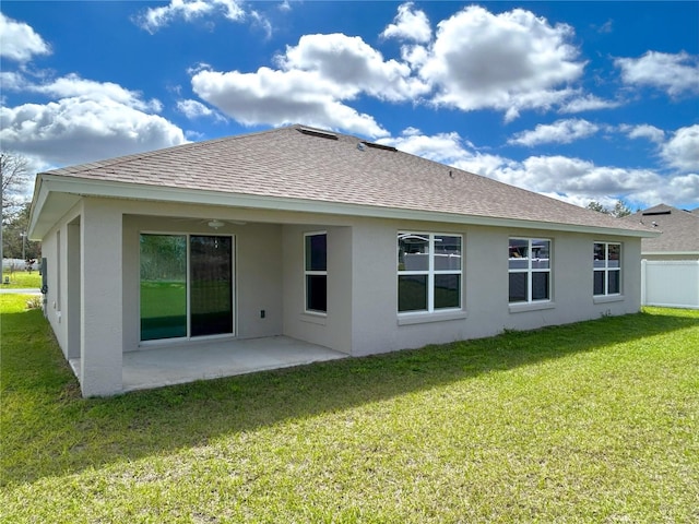 rear view of property with a yard, roof with shingles, a patio area, and stucco siding