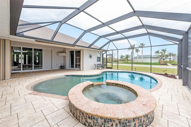 view of swimming pool featuring glass enclosure, a patio area, and a pool with connected hot tub