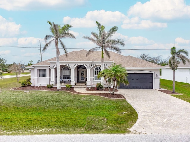 view of front of home with a porch, an attached garage, a front yard, stucco siding, and decorative driveway