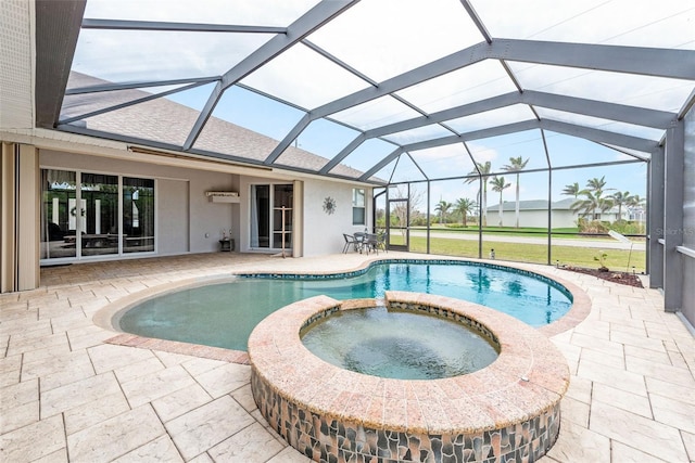 view of pool featuring a pool with connected hot tub, a lanai, and a patio