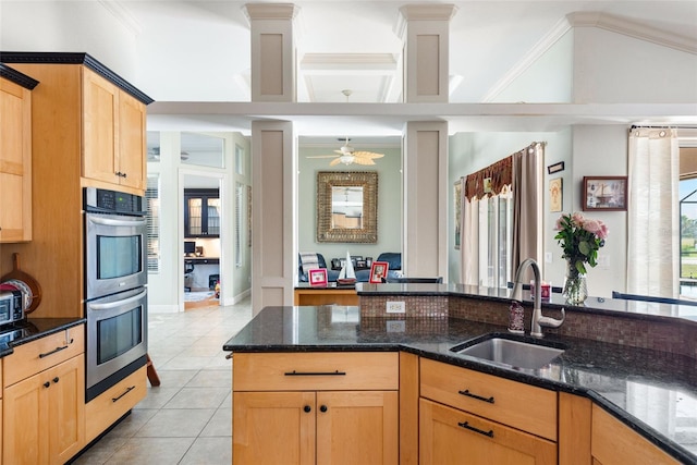 kitchen featuring a sink, dark stone countertops, light tile patterned flooring, stainless steel double oven, and ceiling fan