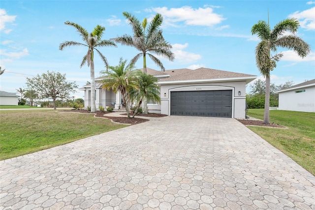view of front of property featuring a garage, stucco siding, a front yard, and decorative driveway